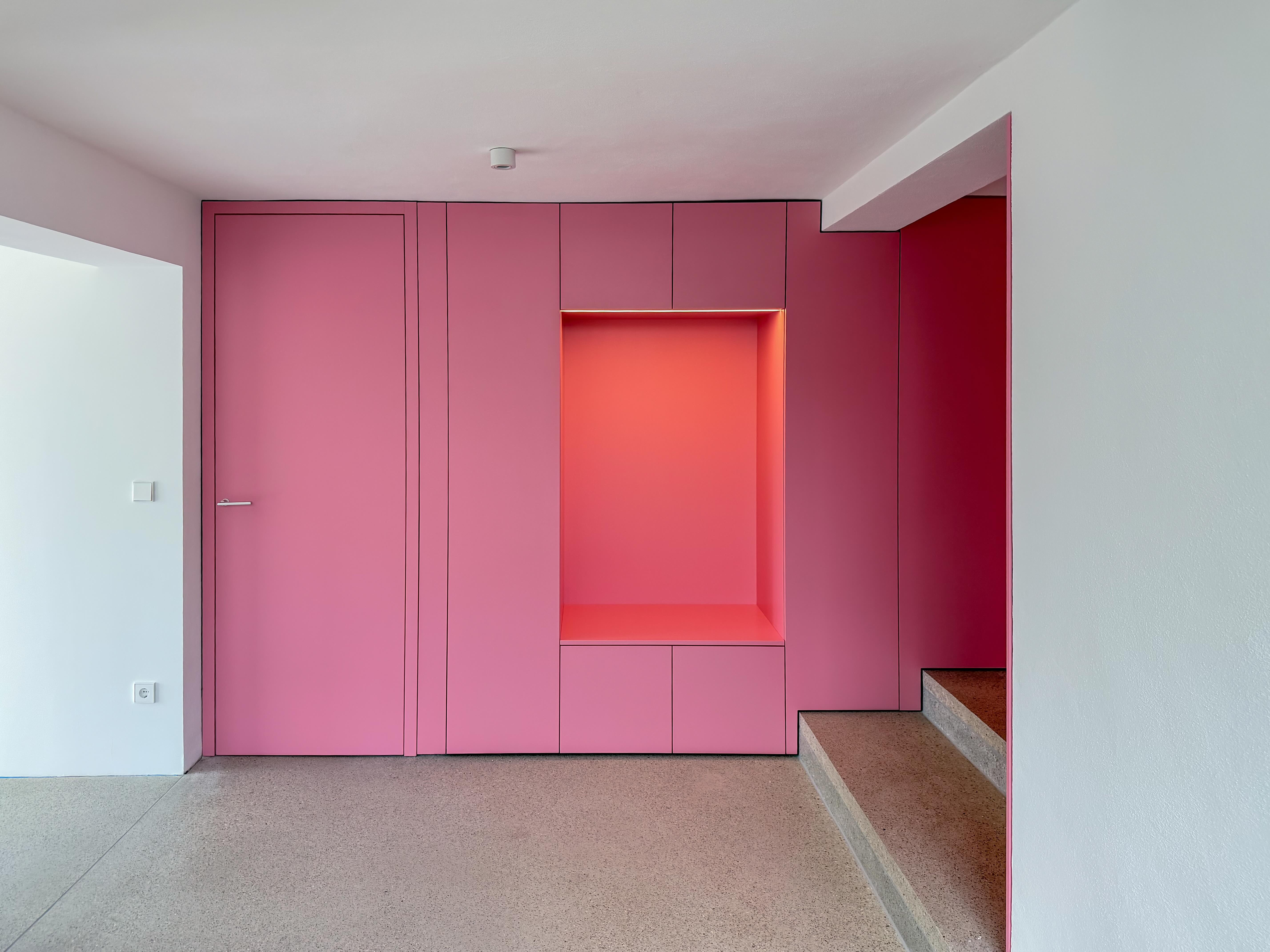 gesamtansicht einer auffälligen, pinken Garderobe im Raum mit Treppenstufen